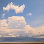 Dramatic cloudscape over flat Gobi steppe with distant mountains