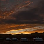 Mongolian ger camp at dramatic sunset with orange sky
