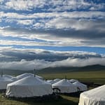 Traditional Mongolian ger camp white tents under dramatic cloudy sky