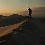 Silhouette of person on sand dune at sunset Mongolia Gobi